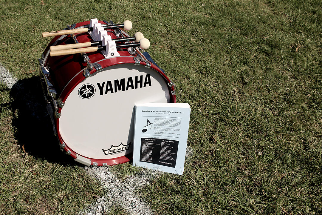 Drumline instruction book on field The drum line teaching book on the field with a bass drum.
